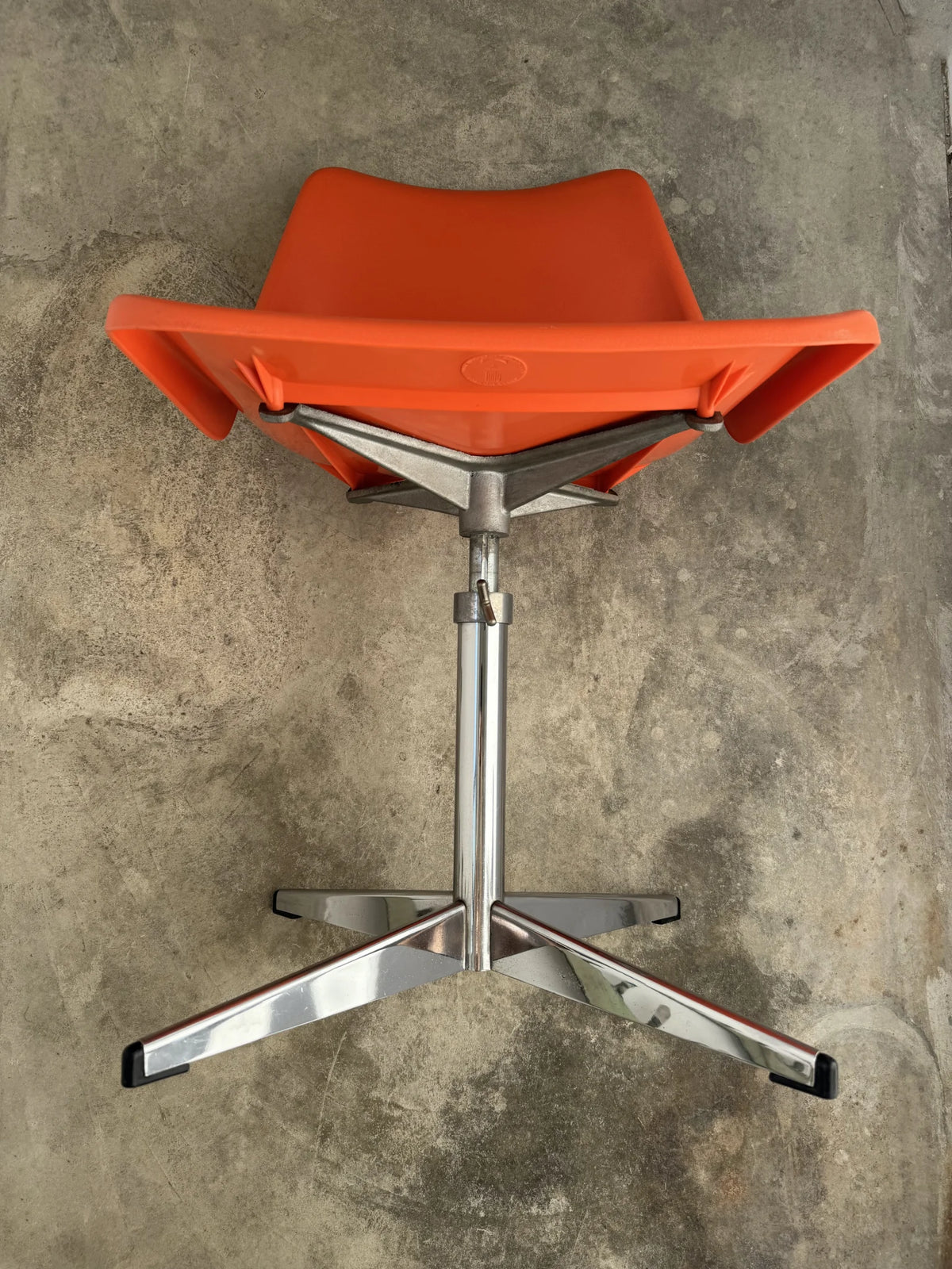 Sedia girevole plastica arancione di Robin Day per Tecno – dettaglio razze cromate