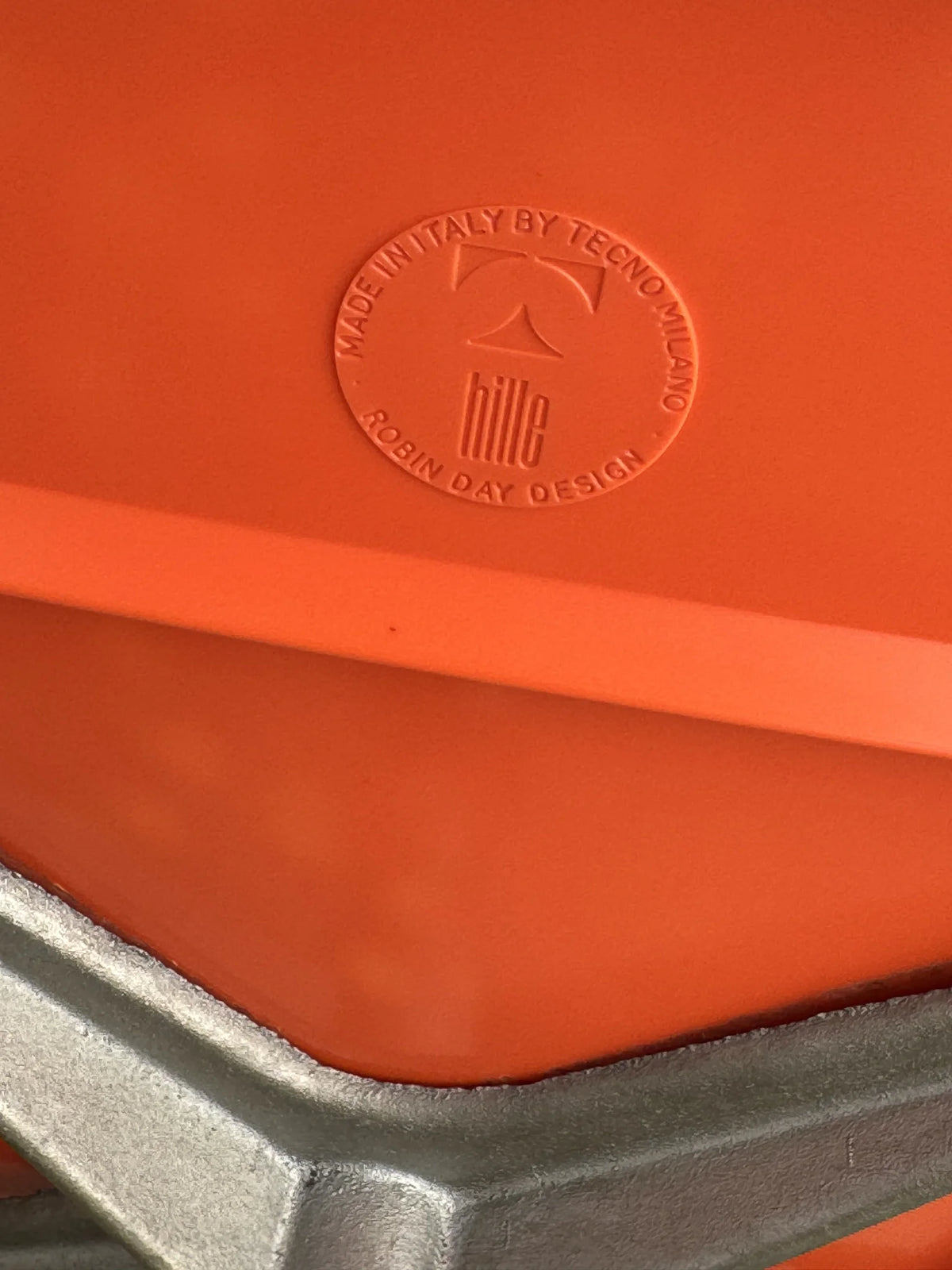 Sedia girevole plastica arancione di Robin Day per Tecno – marchio impresso sul retro della seduta
