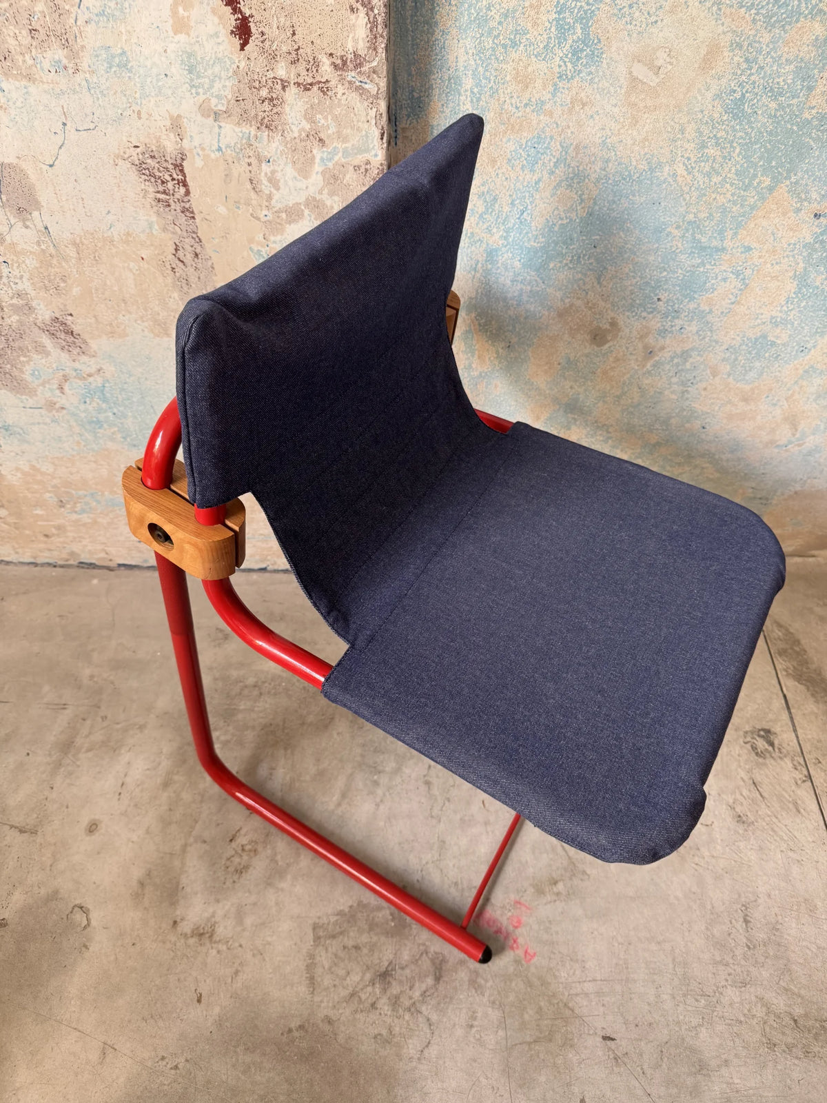 Sedia in metallo rosso con seduta in denim – vista interamente da davanti