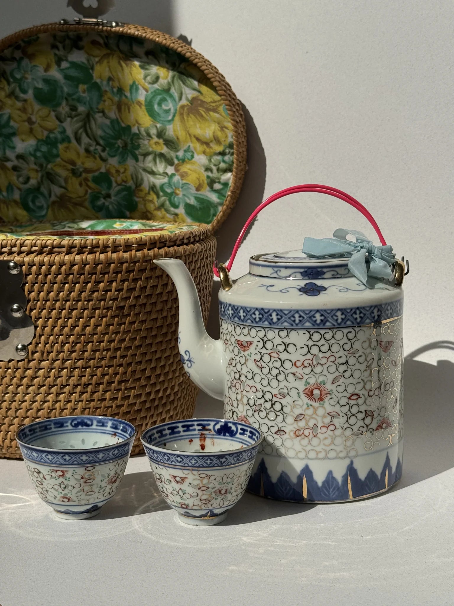 Servizio da tè cinese in porcellana – teiera e due tazze con decorazione blu, bianca e rossa, cestino sullo sfondo