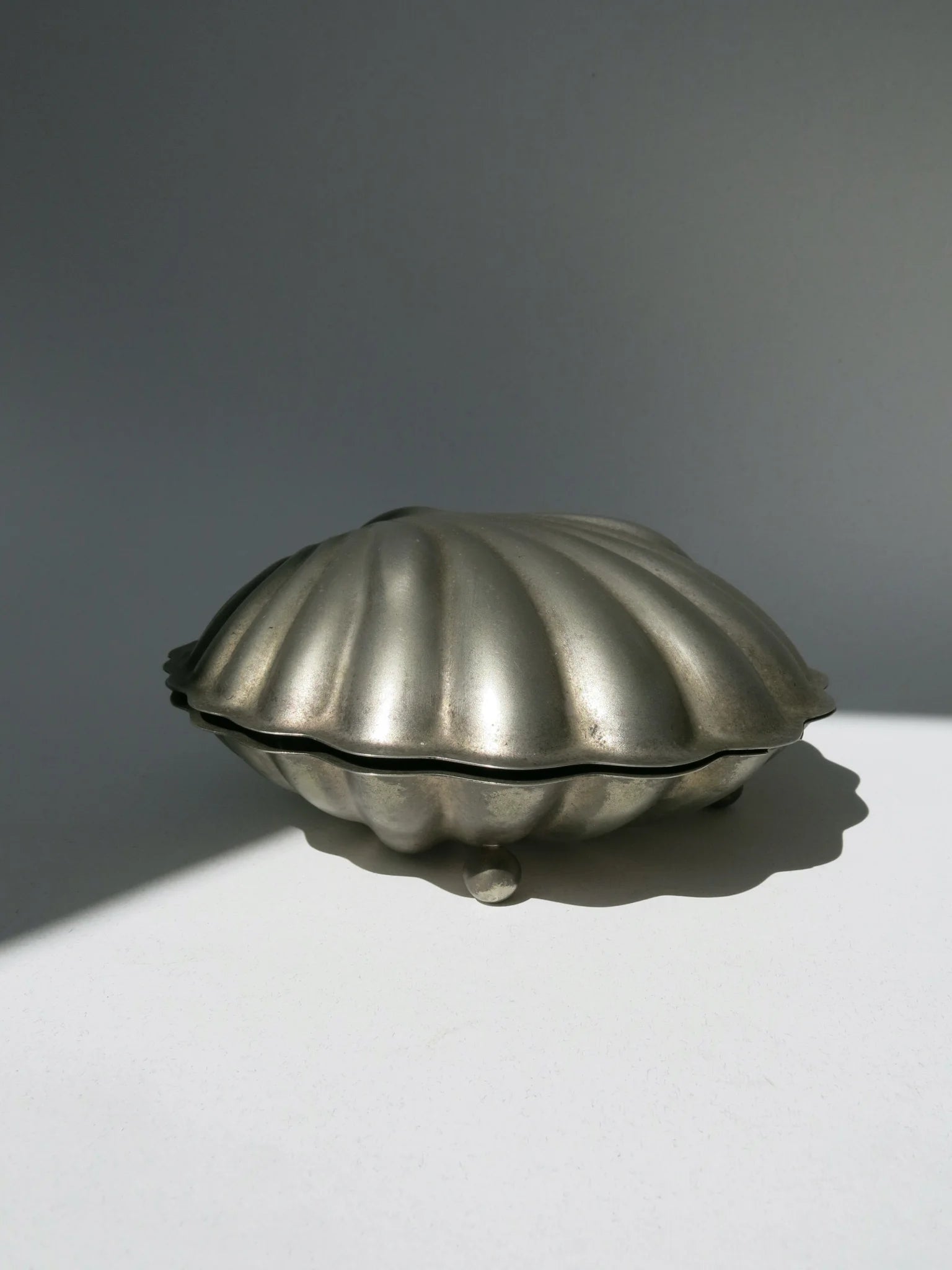 Cofanetto in metallo argentato a forma di conchiglia – vista dal lato della scatola