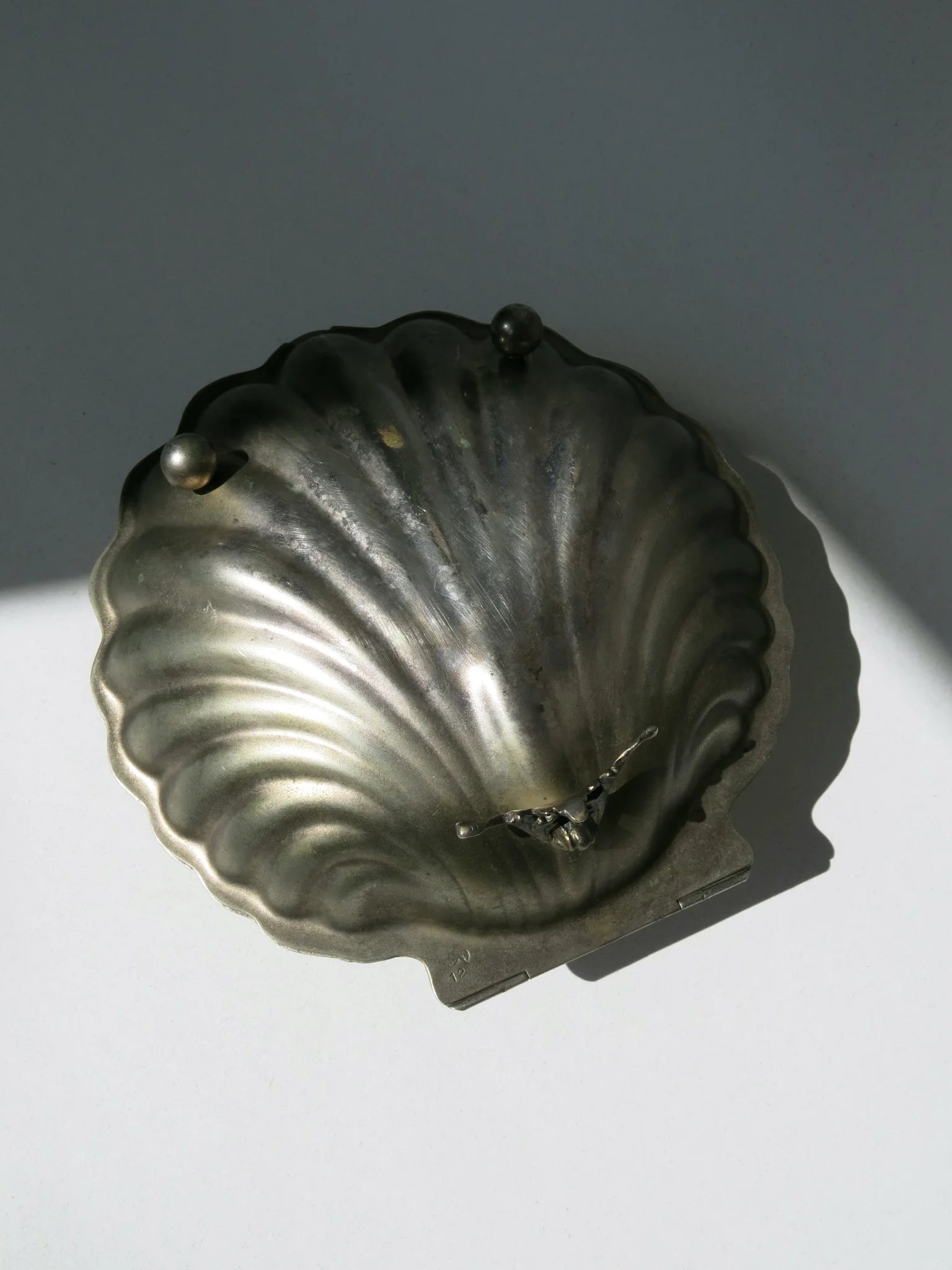 Cofanetto in metallo argentato a forma di conchiglia – retro con piedini di appoggio