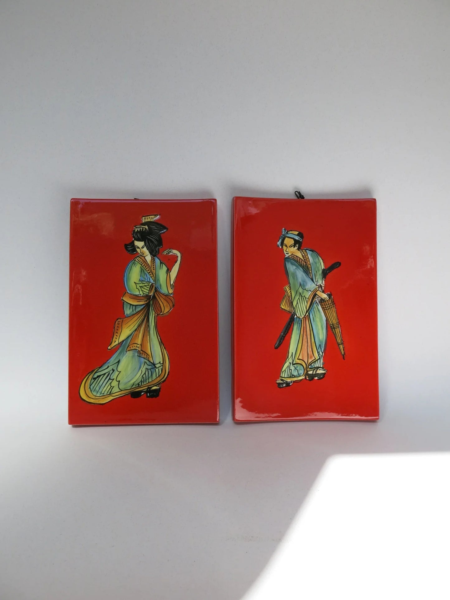 Coppia mattonelle ceramica smaltata S.I.C.A.S Firenze – dipinte a mano, figure orientali su fondo rosso, gancio originale
