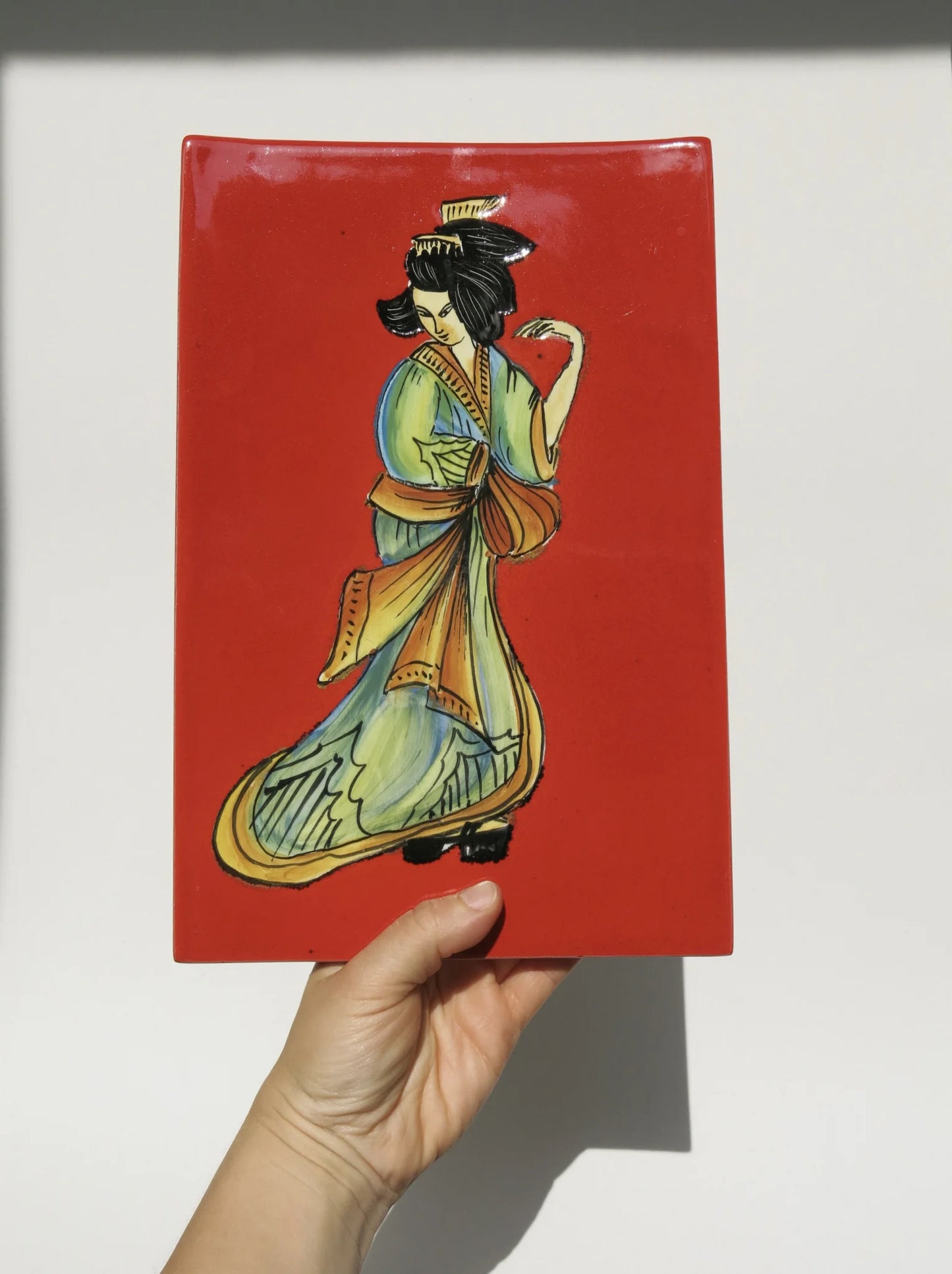 Mattonella ceramica smaltata S.I.C.A.S Firenze – in mano per mostrare le proporzioni, fondo rosso con figura orientale