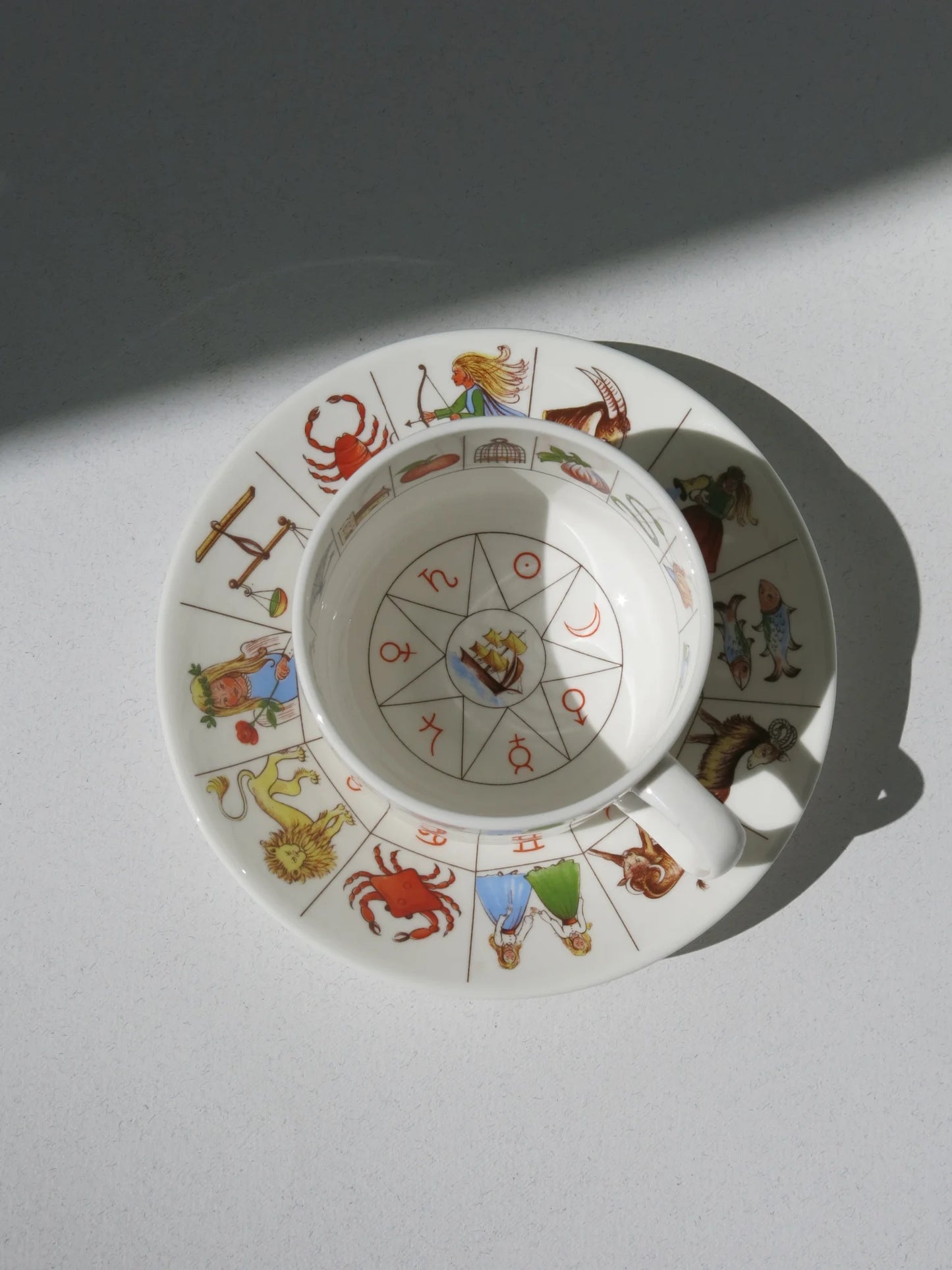 Tazza divinatoria Royal Kendal bone china – vista frontale con scritta corsiva e piattino zodiacale