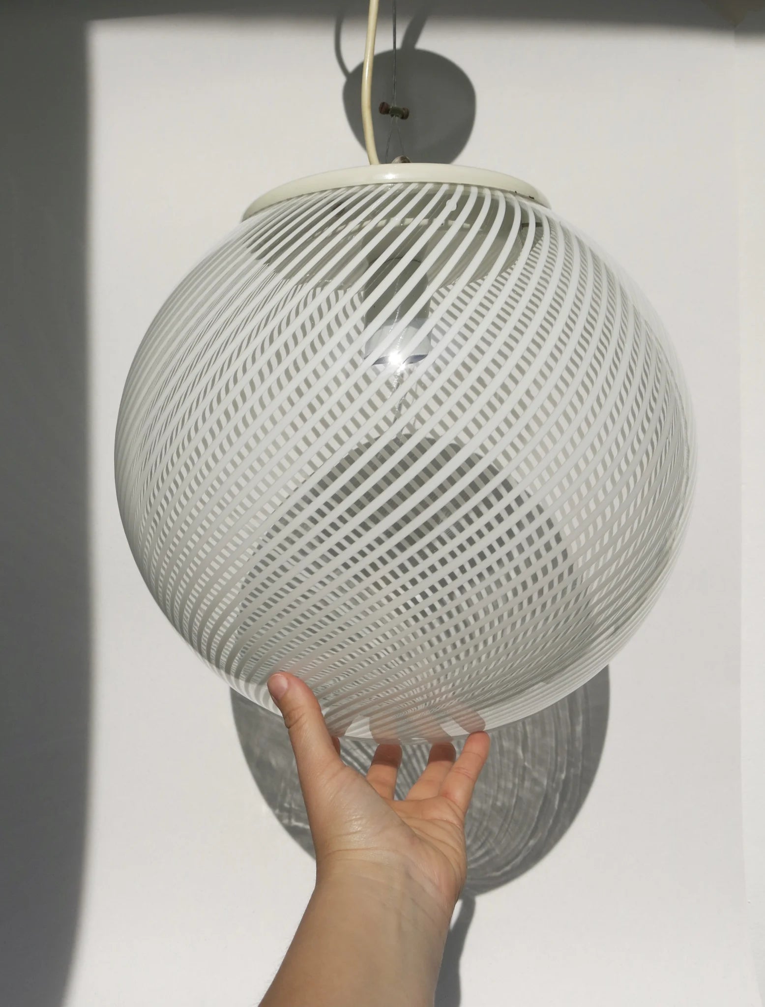 Lampadario a sfera in vetro soffiato – in mano per mostrare le proporzioni, motivo a canne bianche intrecciate