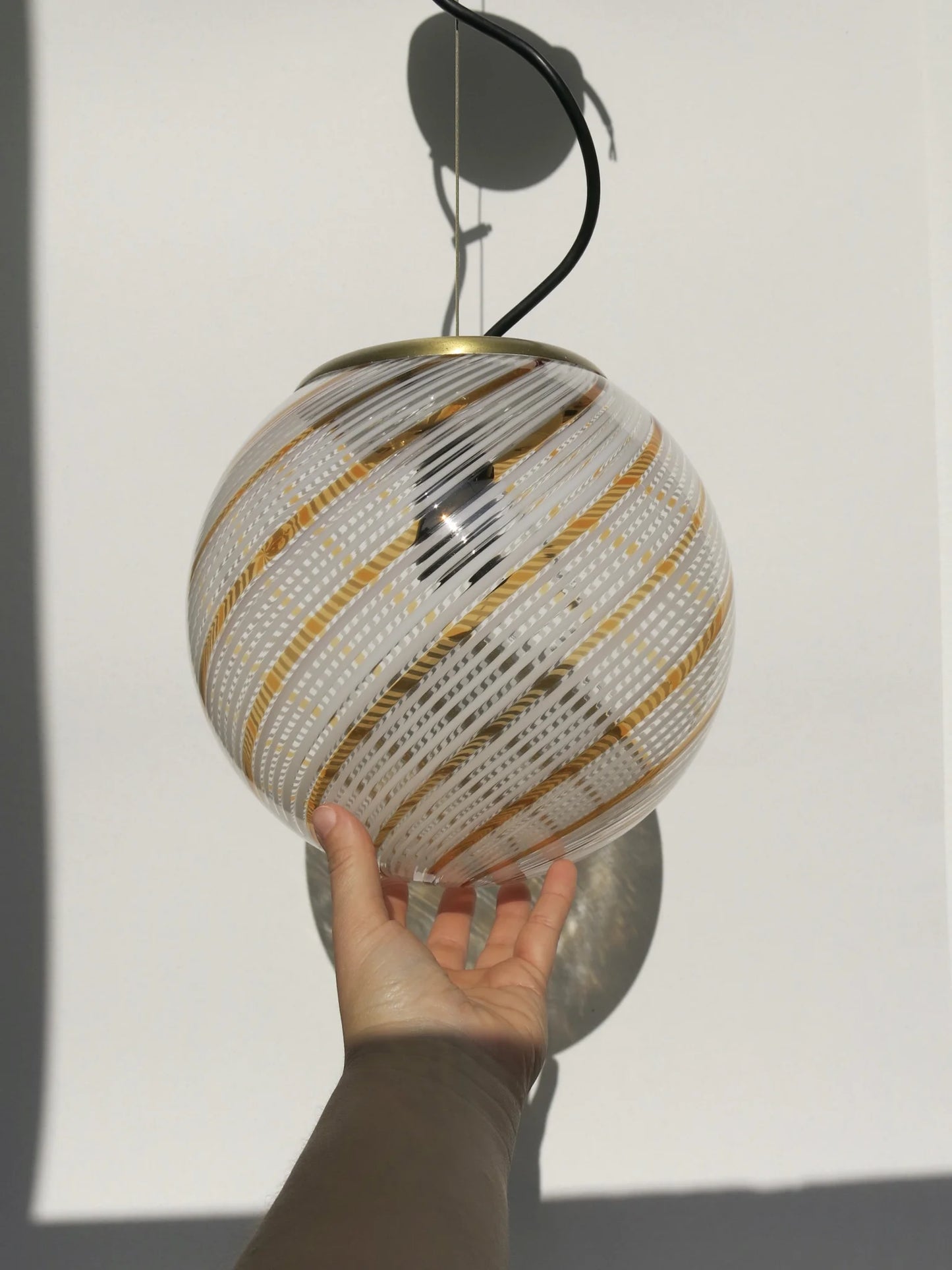 Lampadario di Murano a sfera in vetro soffiato – in mano per mostrare le proporzioni, filigrana a spirale bianca e oro