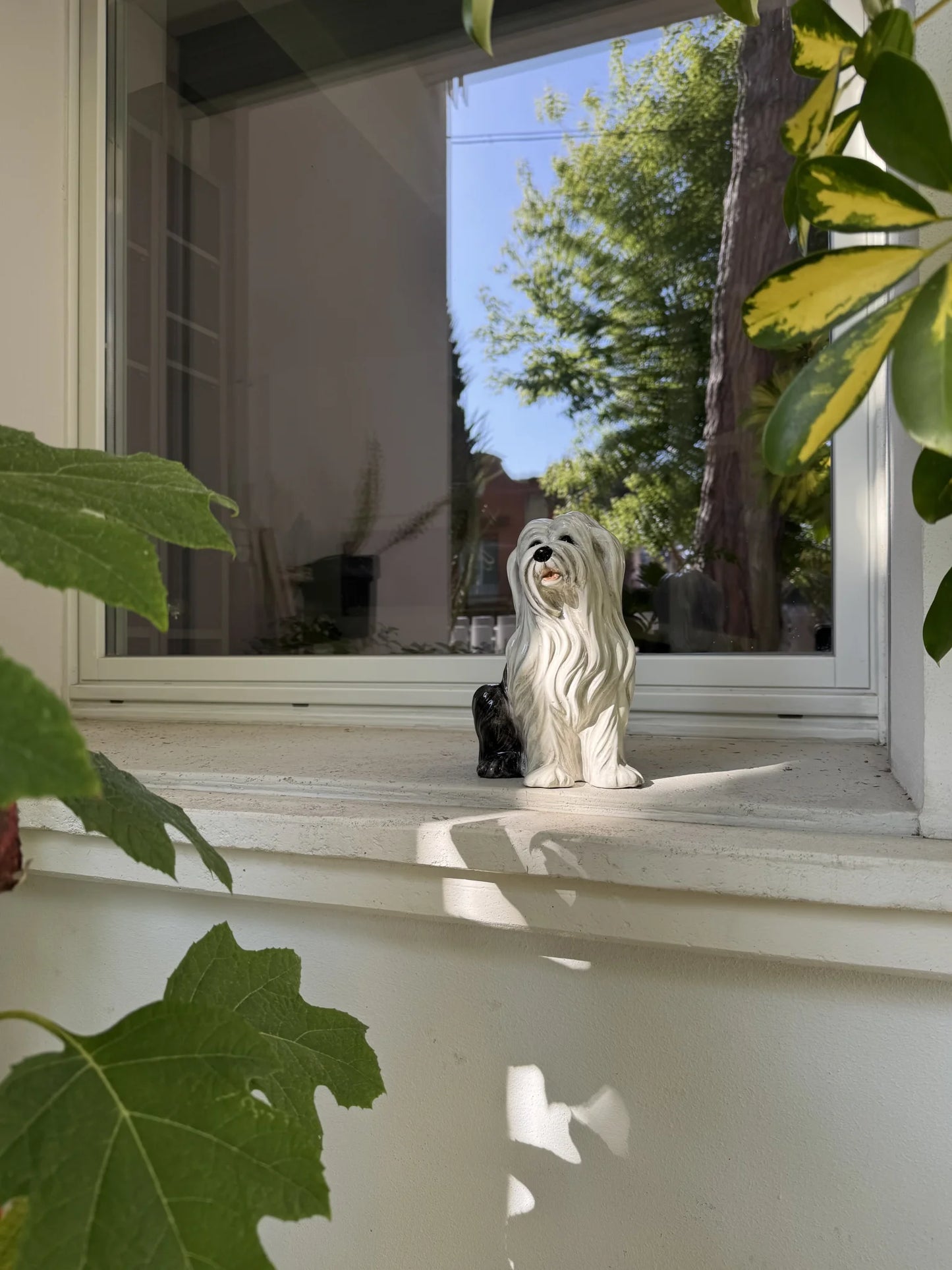 Cane in ceramica decorato a mano – ambientato su davanzale in un giardino
