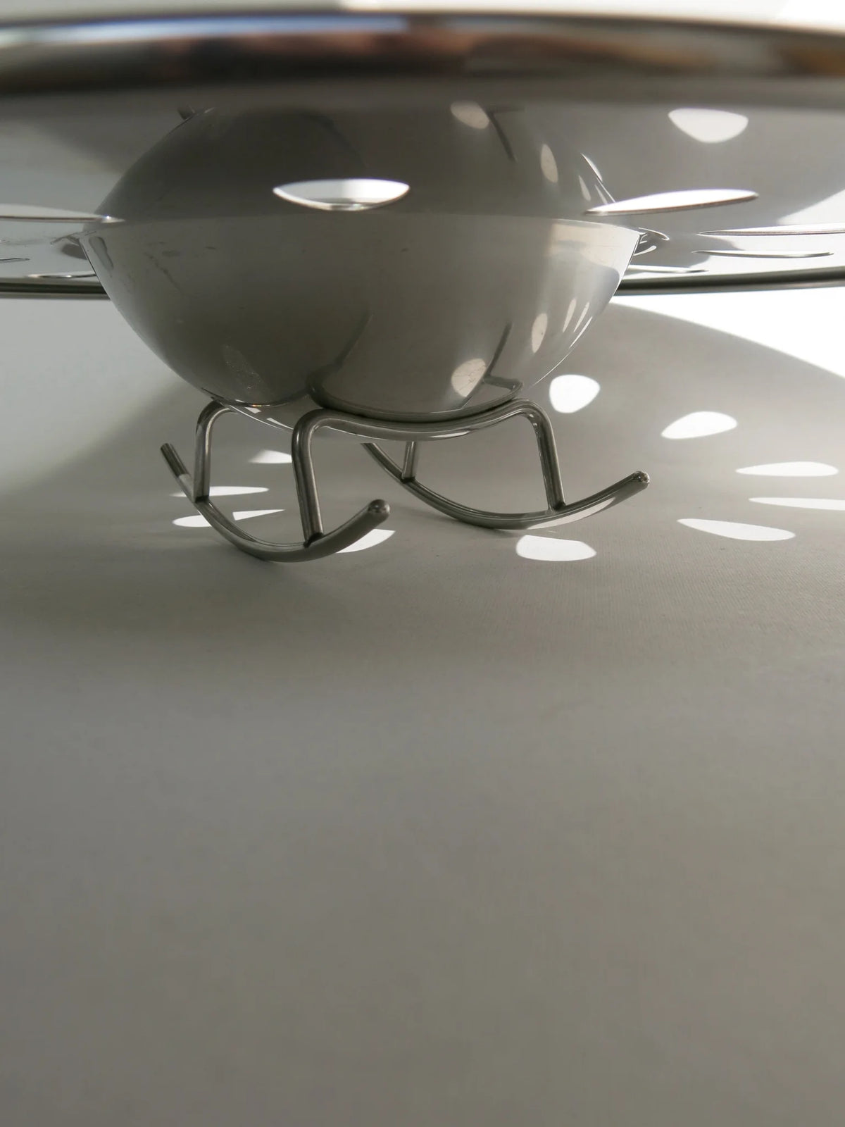 Centrotavola in acciaio Alessi mod. Swing – dettaglio base a slitta
