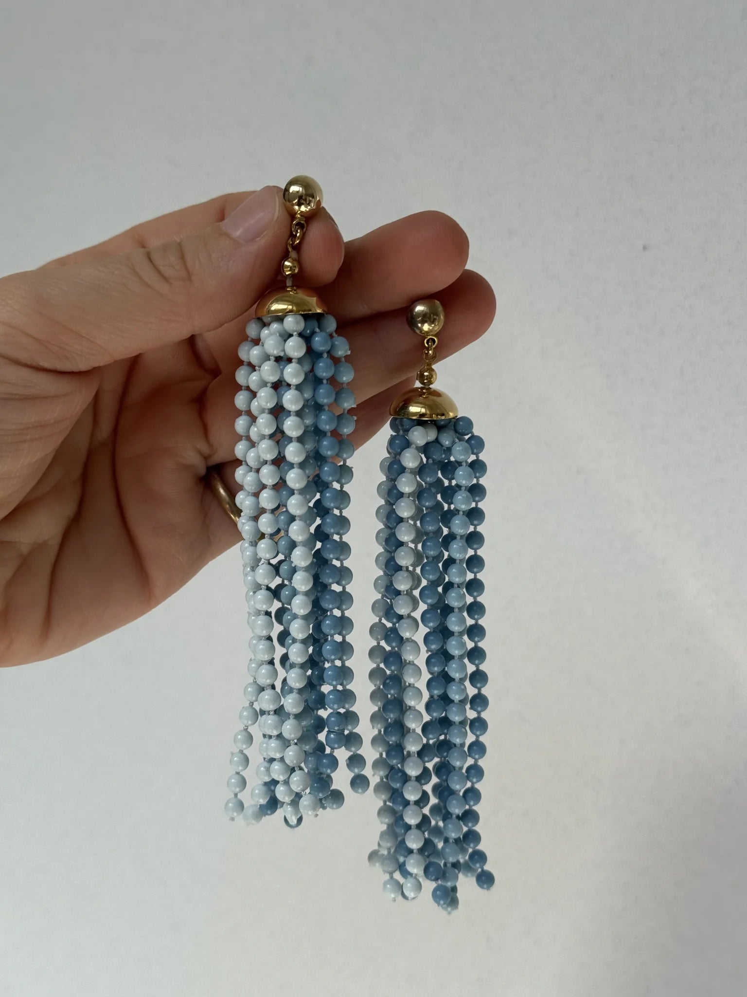 Orecchini vintage fili plastica azzurra – tenuti in mano per proporzione