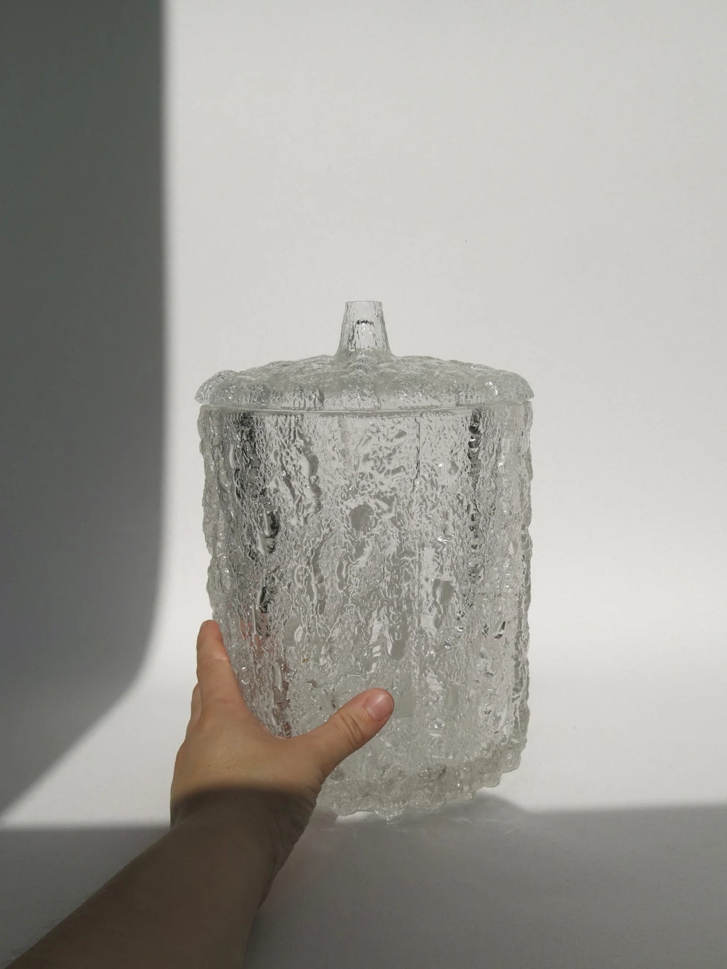 Contenitore vaso in vetro in rilievo effetto ghiaccio con coperchio dello stesso materiale con una mano a lato