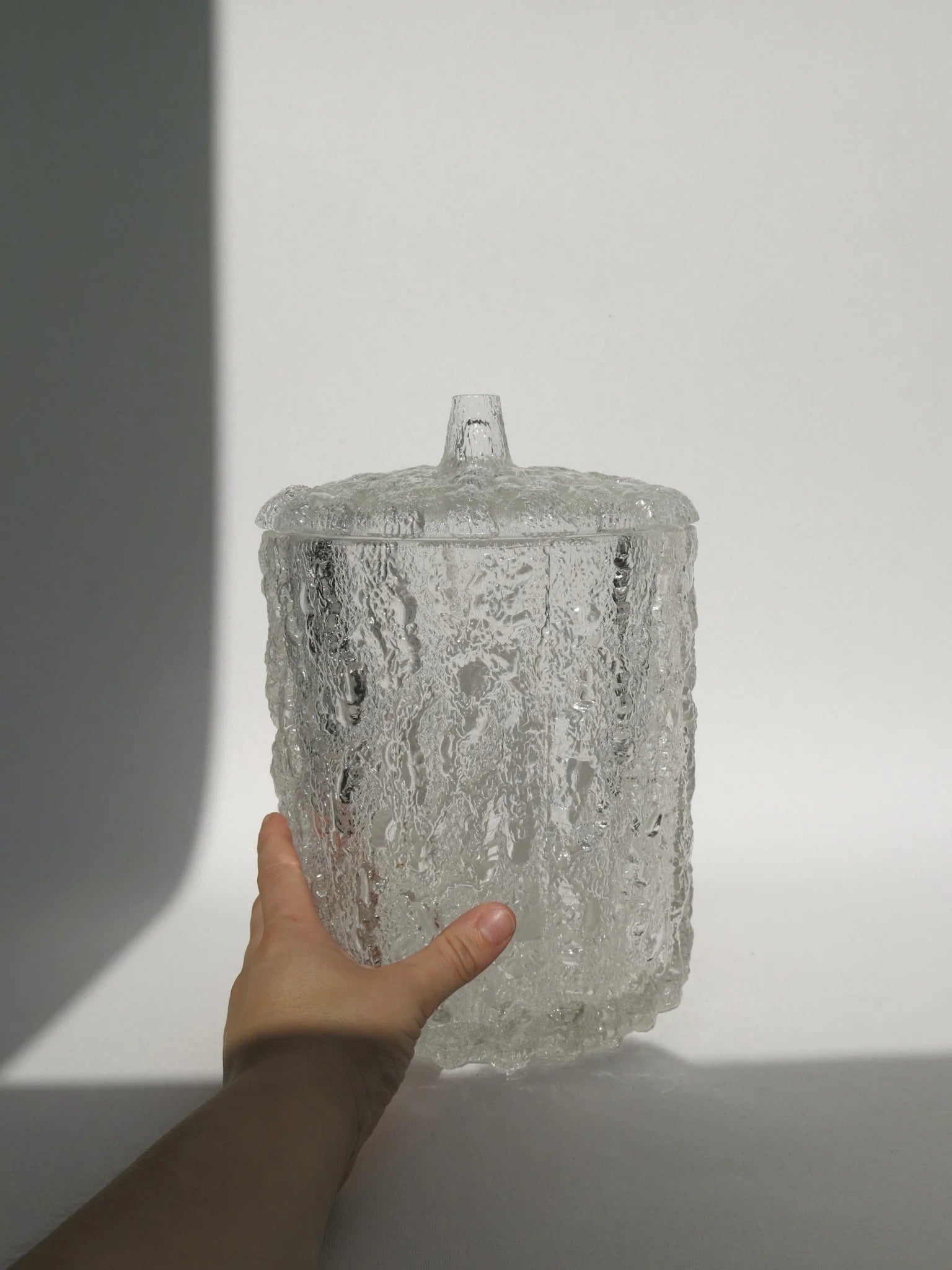 Contenitore vaso in vetro in rilievo effetto ghiaccio con coperchio dello stesso materiale con una mano a lato