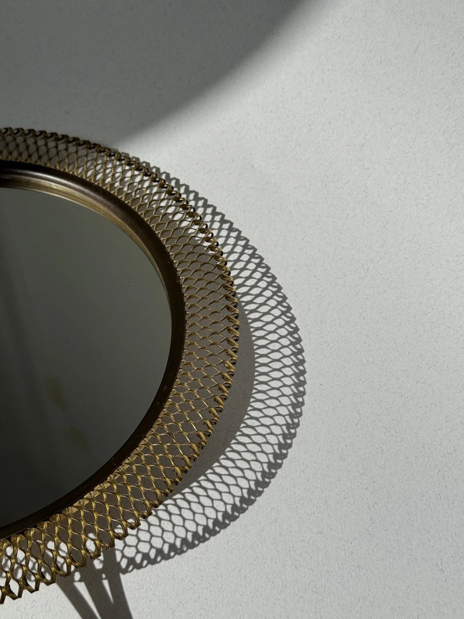 Specchio a mano in ottone traforato – dettaglio lavorazione cornice traforata con ombra
