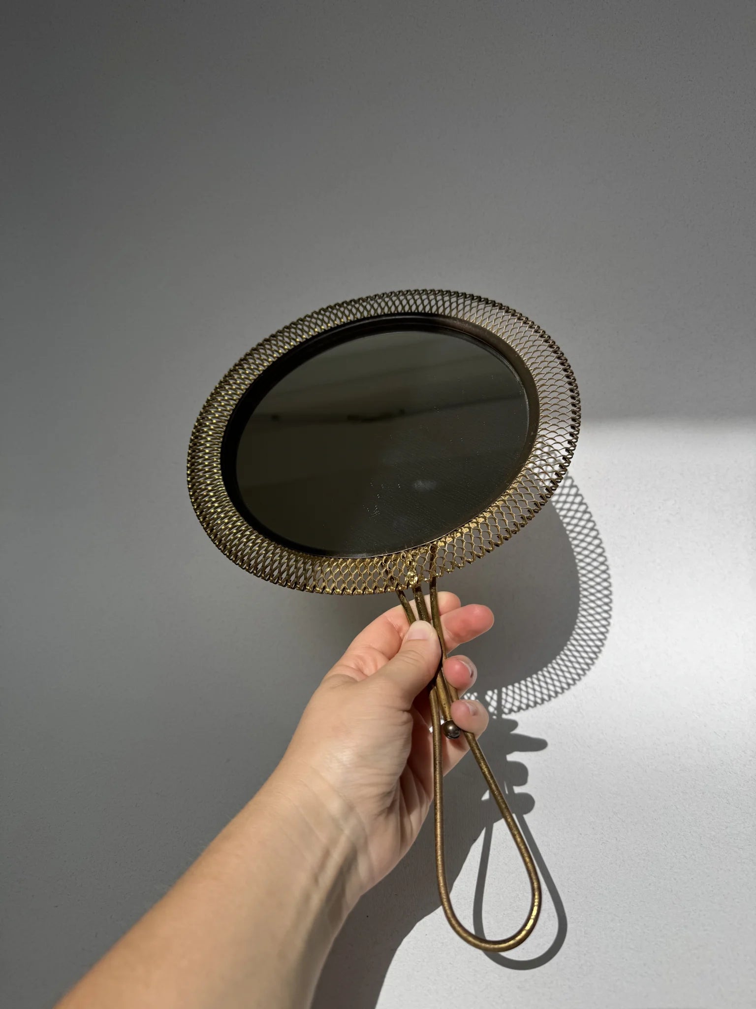 Specchio a mano in ottone traforato – tenuto in mano