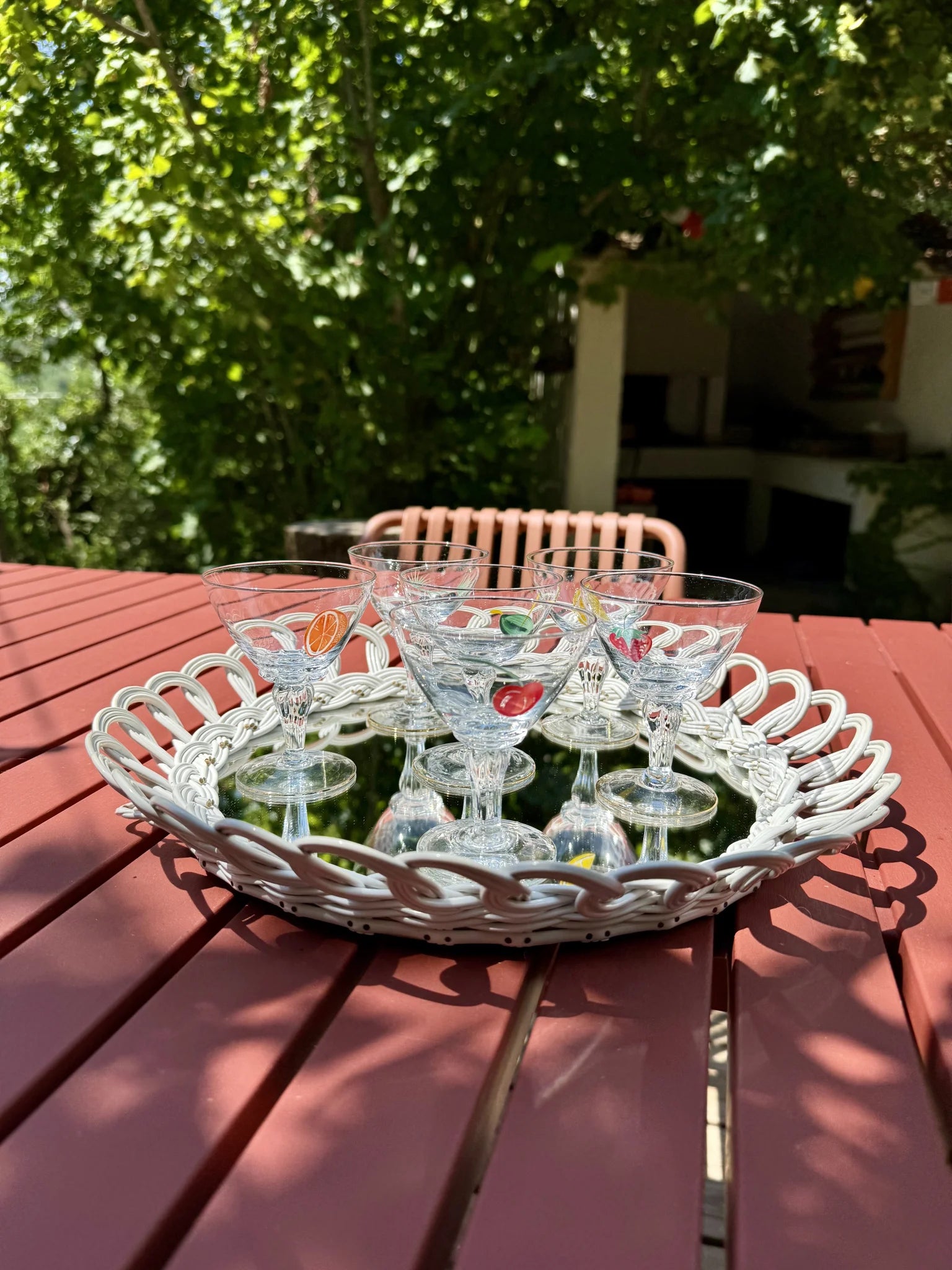 Set bicchieri da liquore Tutti Frutti – disposti sopra un vassoio bianco in un giardino