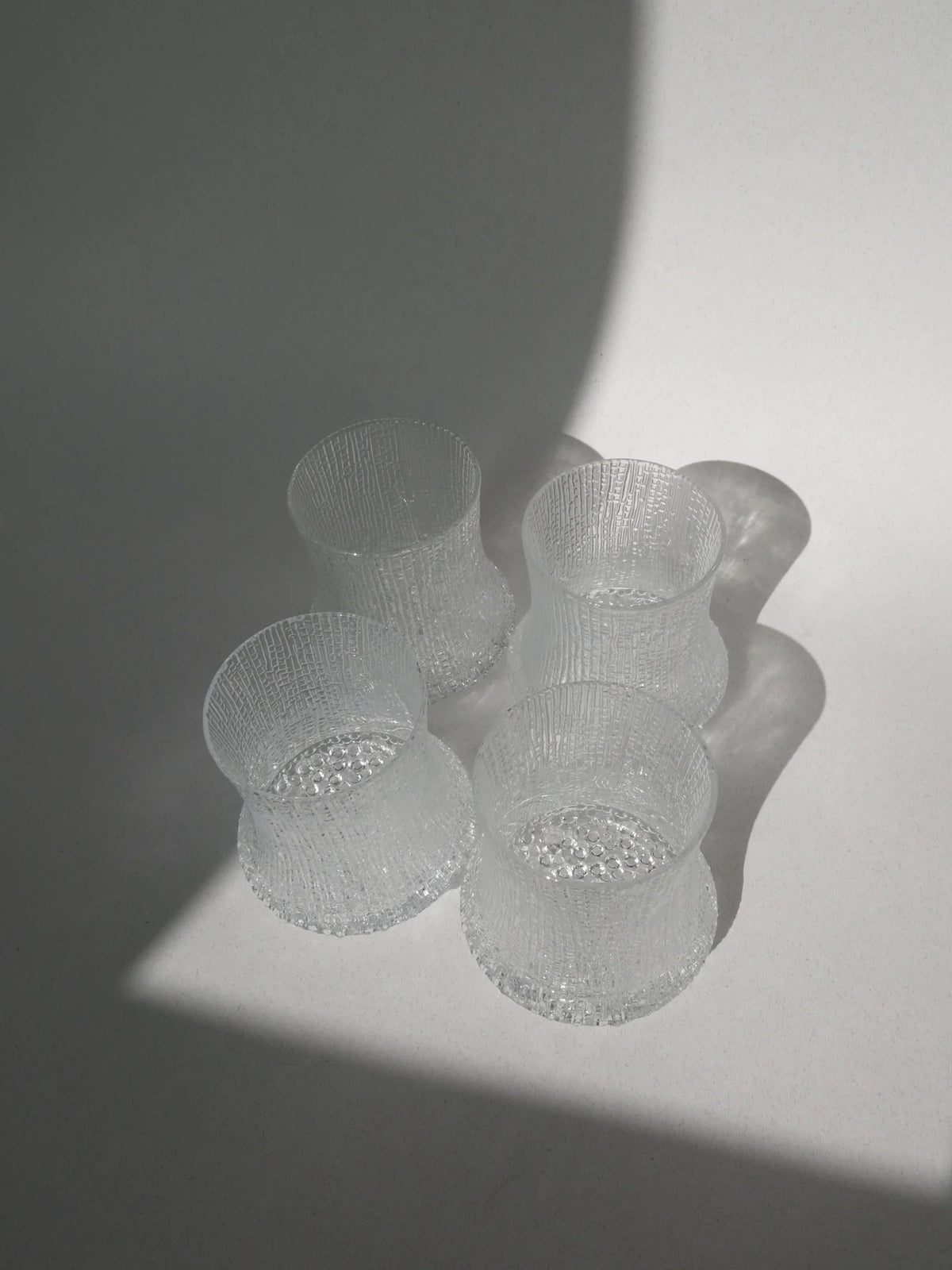 Set di 4 bicchieri acqua modello Ultima Thule di Iittala – visti dall'alto con luce radente