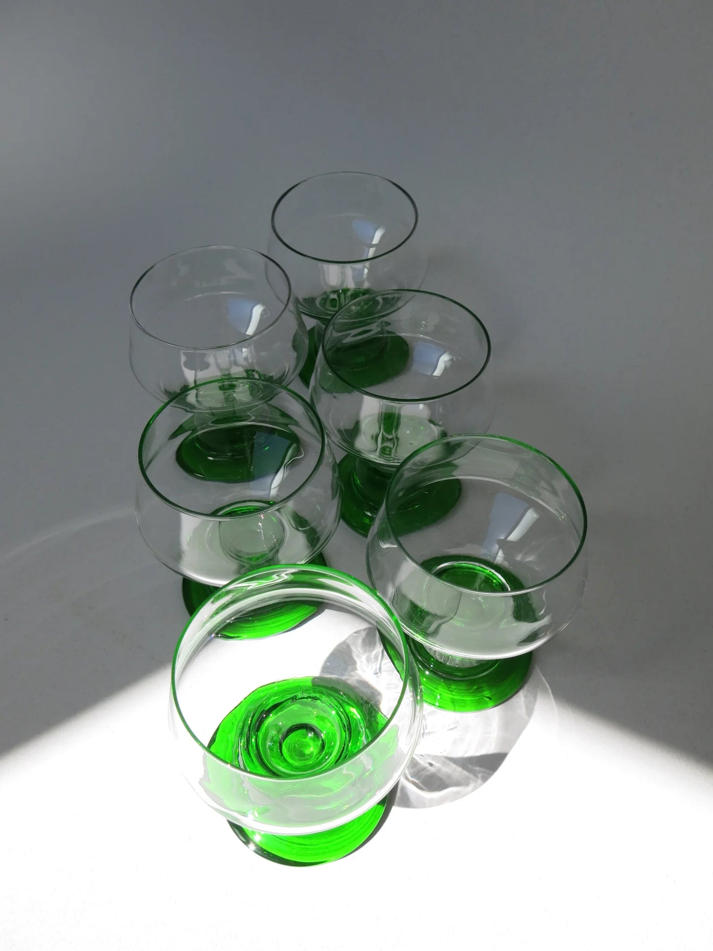 Bicchieri da acqua in vetro – dettaglio stelo e base verde smeraldo, luce radente con ombre