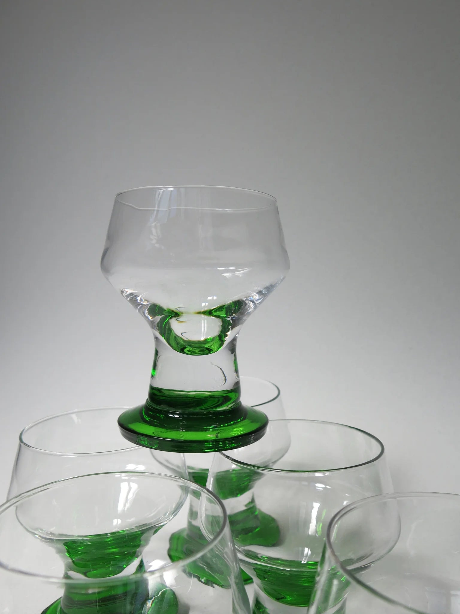 Bicchiere da acqua in vetro singolo in cima – base verde smeraldo e stelo, vista frontale ravvicinata