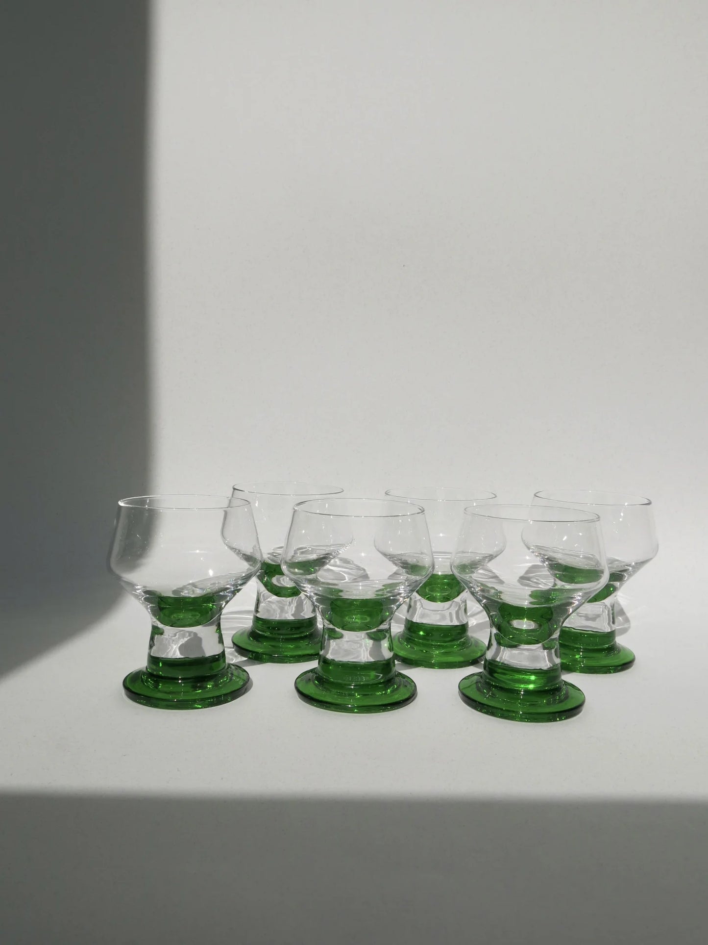 Set 6 bicchieri da acqua in vetro – fila frontale con base verde smeraldo, luce naturale radente