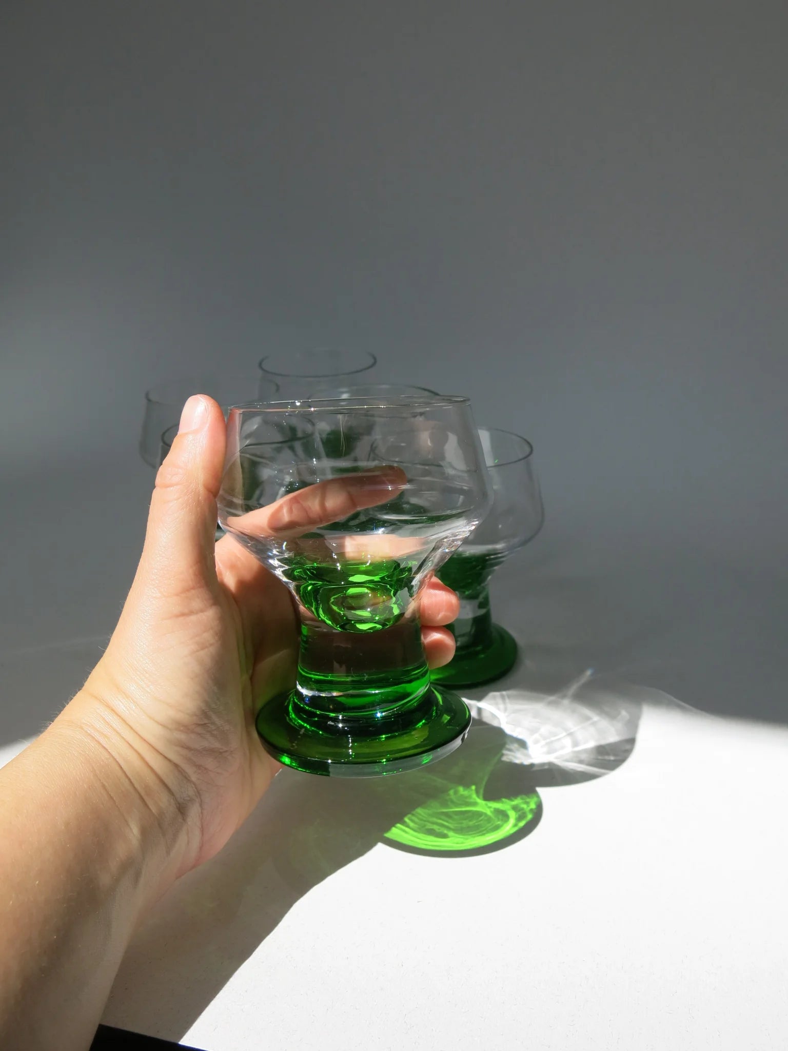 Bicchiere da acqua in vetro– in mano per mostrare le proporzioni, base verde smeraldo
