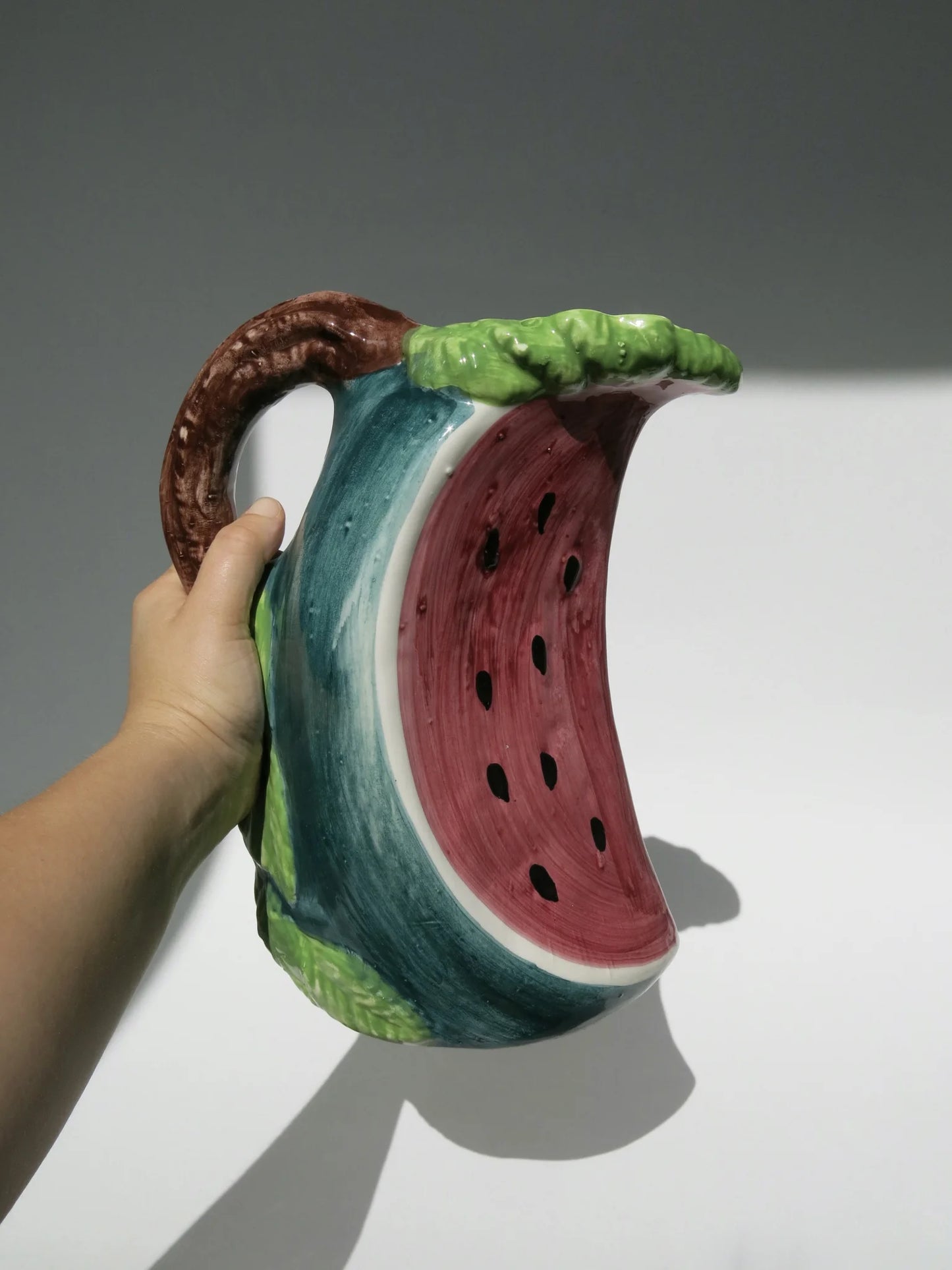 Brocca ceramica a forma di fetta di anguria – vista completa tenuta in mano