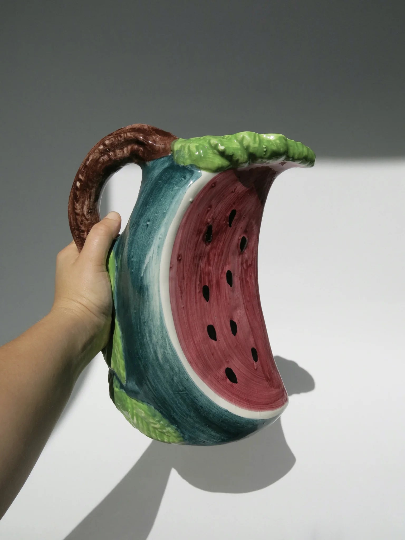 Brocca ceramica a forma di fetta di anguria – vista completa tenuta in mano