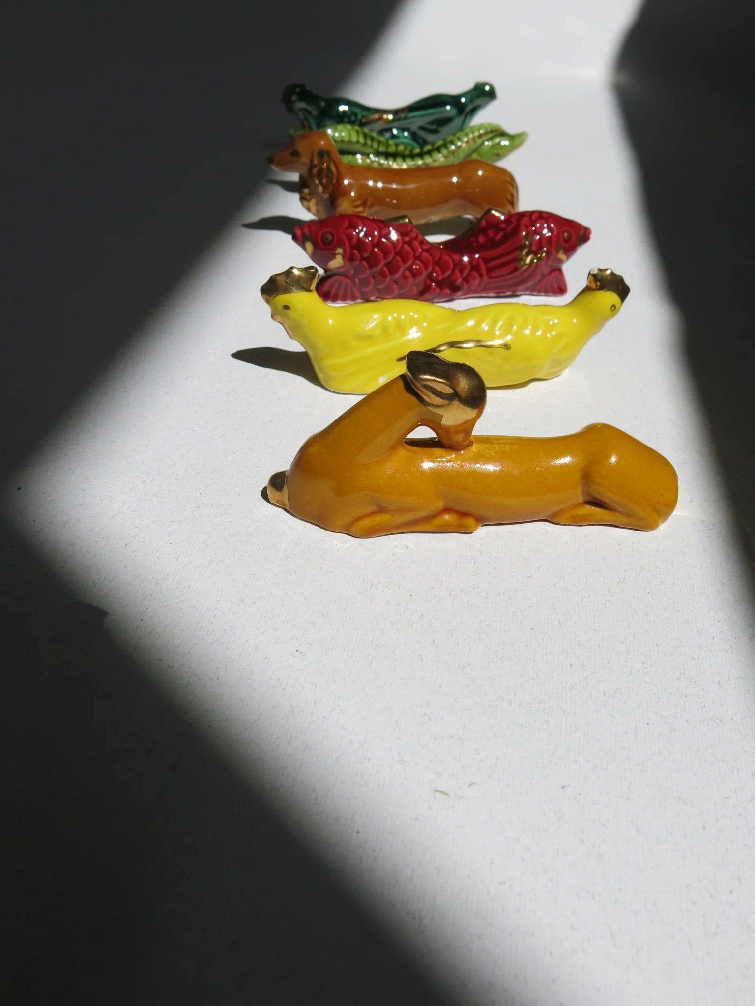 Set di reggi posate in ceramica a forma di animali – dettaglio degli animaletti visti dal lato con luce radente