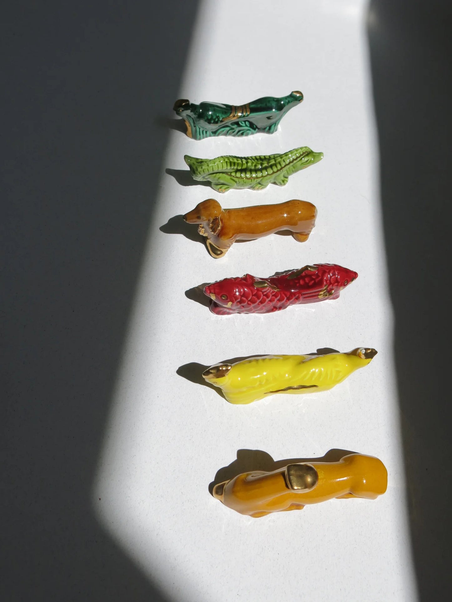 Set di reggi posate in ceramica a forma di animali – vista frontale di cerbiatto, gallina, pesce, cane, coccodrillo e fagiano