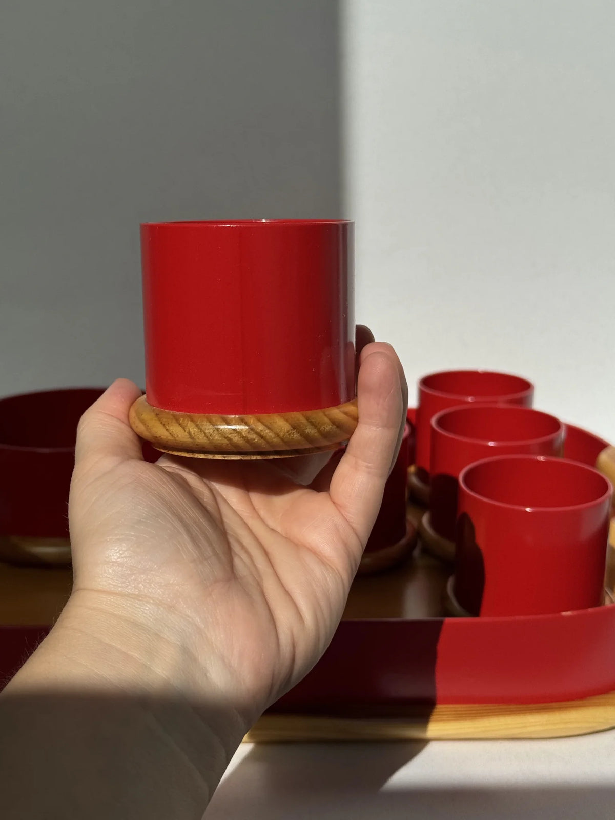 Vassoio in legno e metallo rosso Artek Made in Italy – porta bicchiere tenuto in mano per proporzione