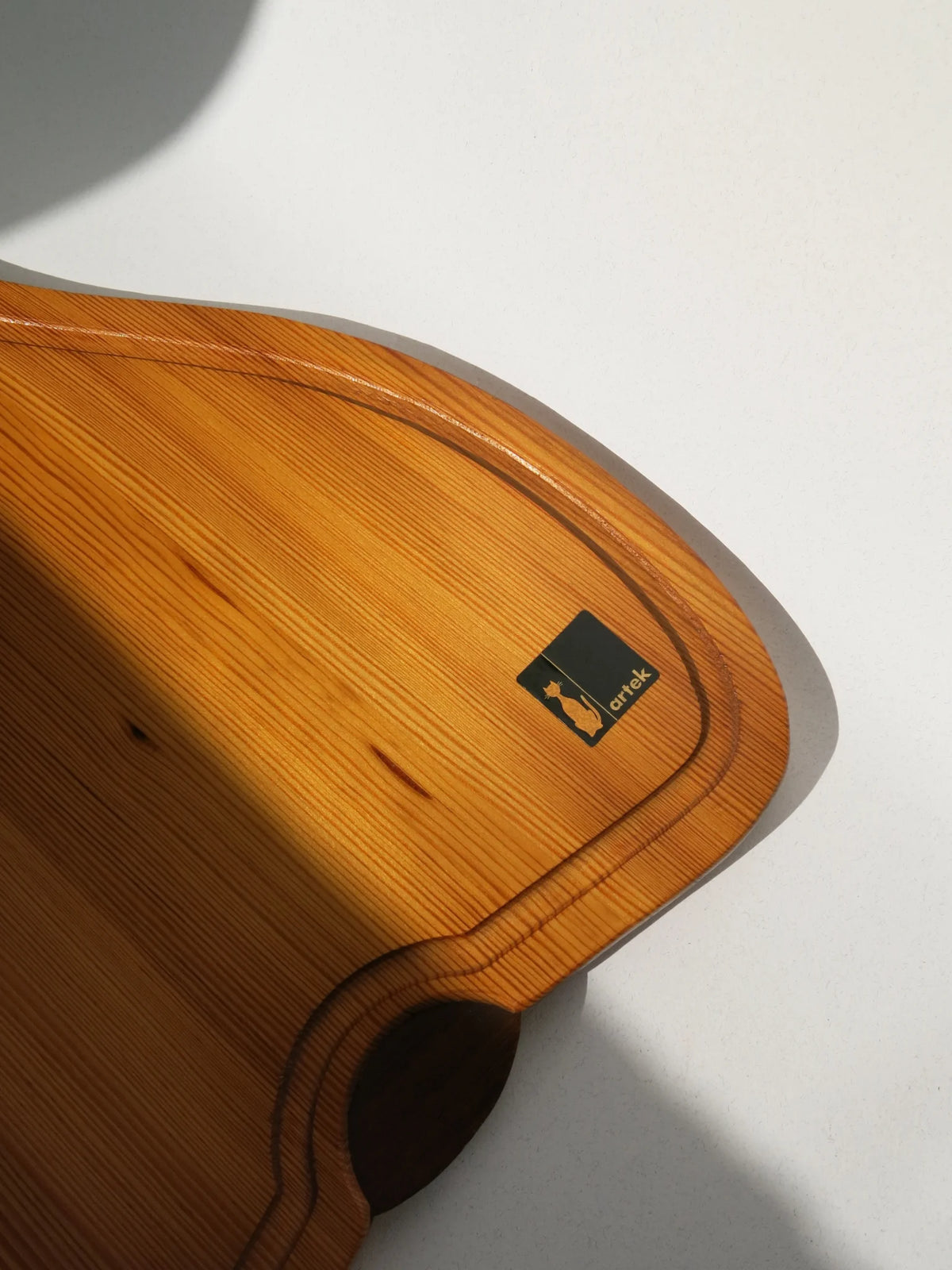 Vassoio in legno a forma di pera Artek Made in Italy – dettaglio marchio a forma di gatto stilizzato arancione